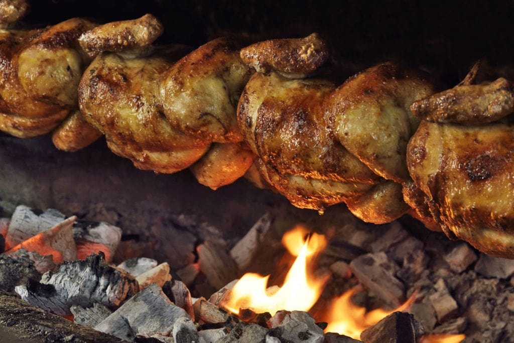 Chickens roasting over charcoal