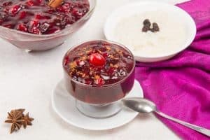 purple corn pudding in bowl with spoon and anise