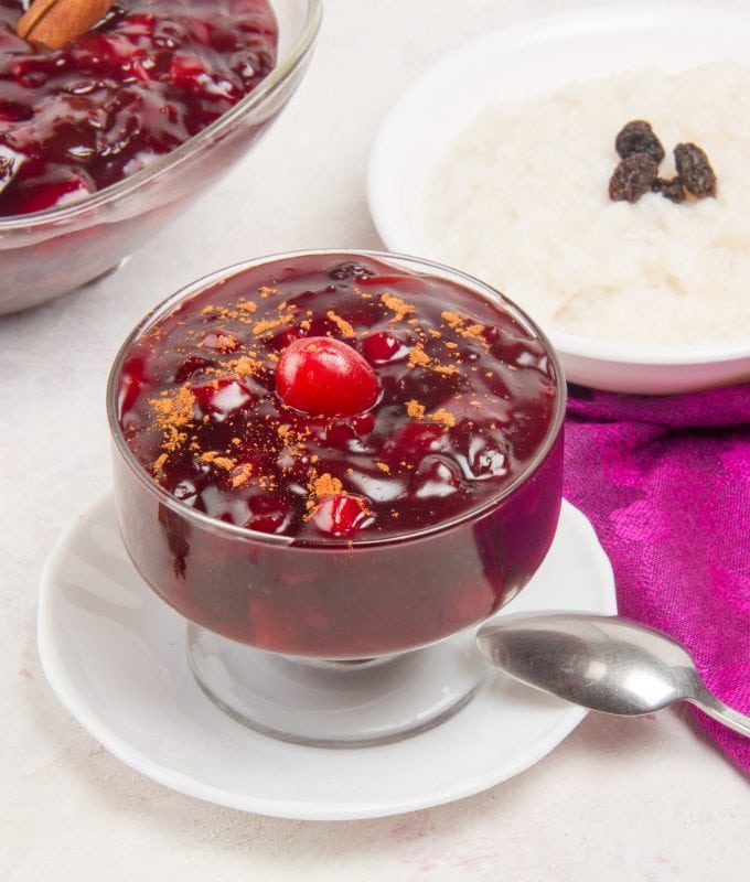 purple corn pudding in bowl with spoon and anise