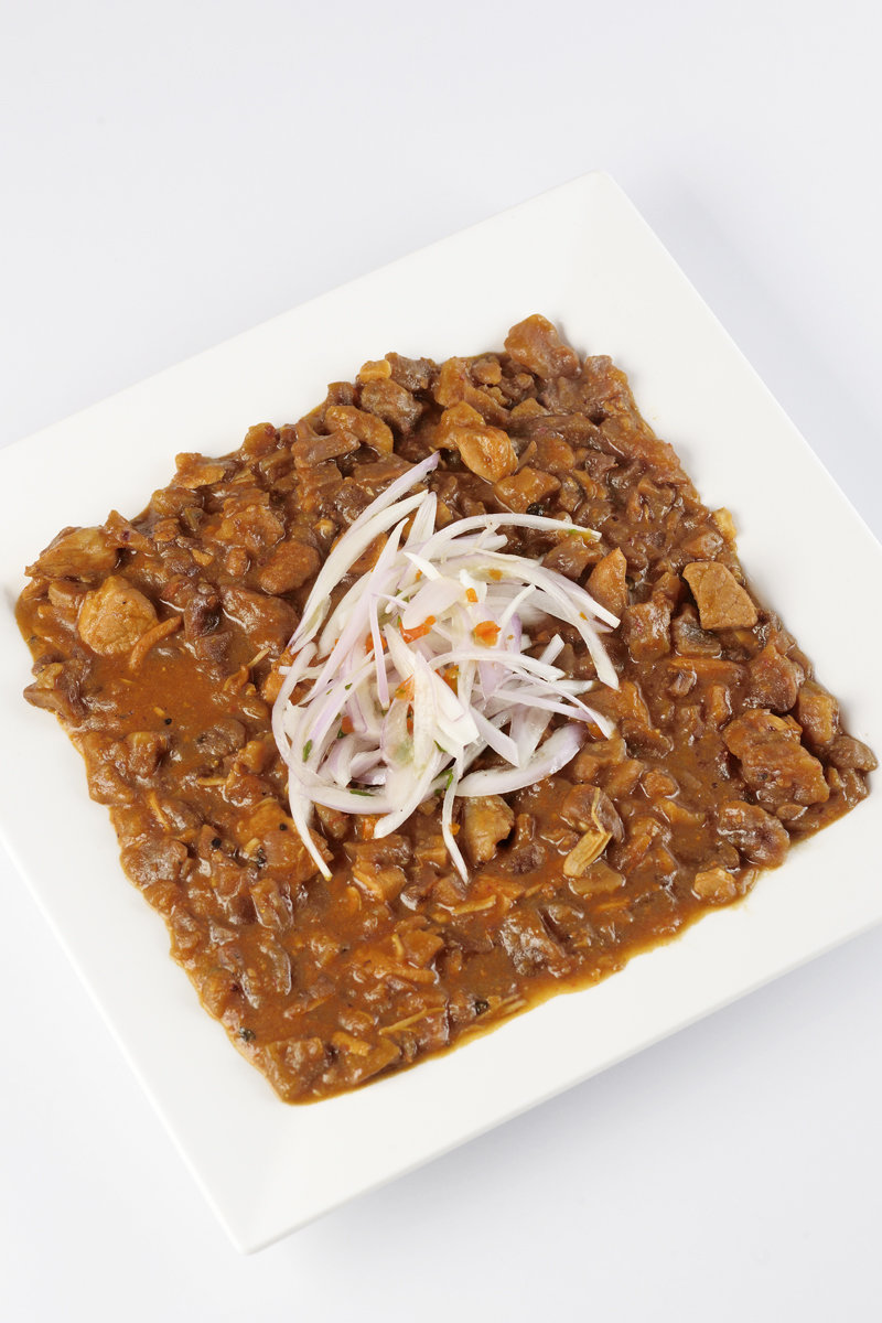 Carapulcra Peruvian stew on plate with onion salad