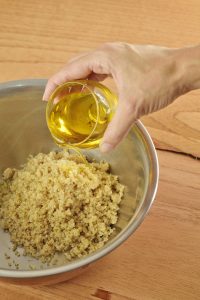 add olive oil to quinoa in large bowl and mix
