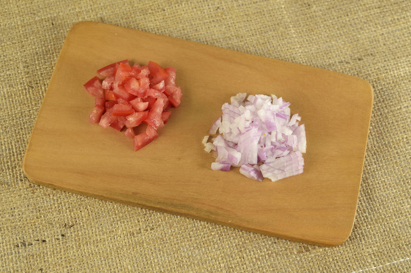 chopped tomatoes and onions on cutting board