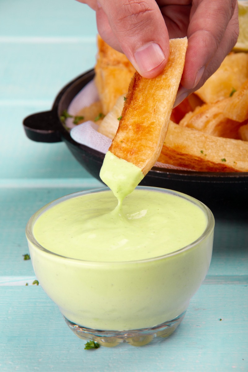 Dipping Fried Yuca Stick Into Avocado Sauce