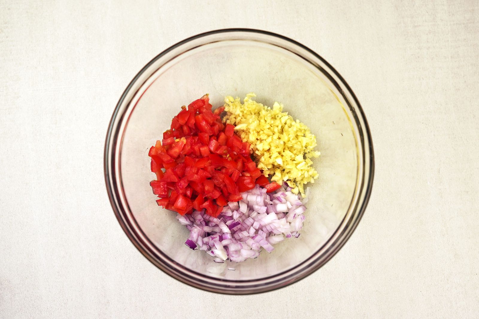 step 3 tossing onions tomatoes garlic in bowl