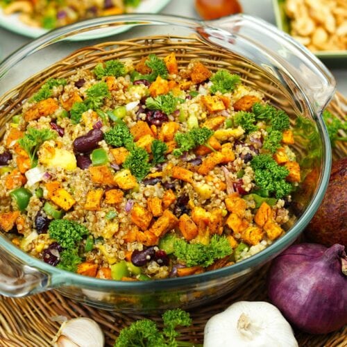 Colorful quinoa vegetable salad in glass bowl.